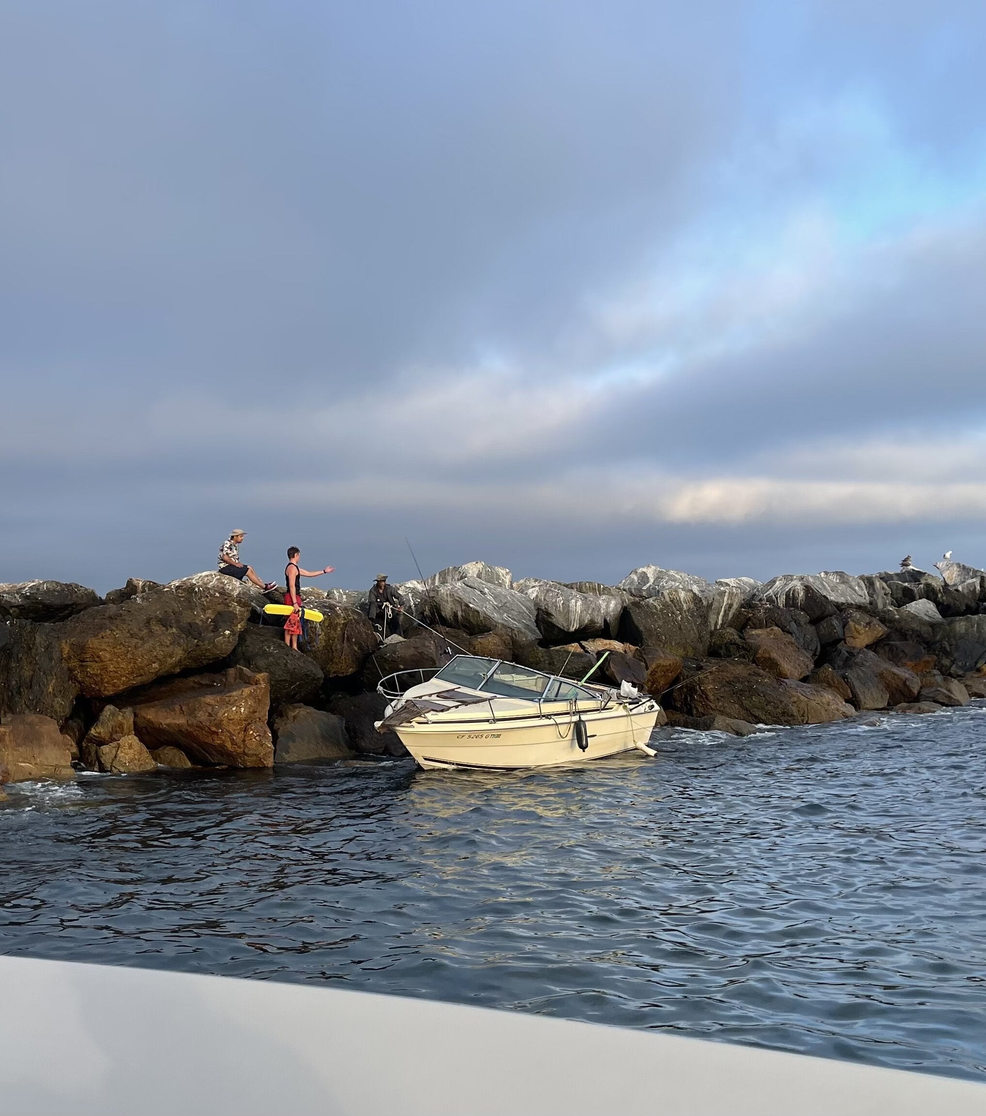 Newport Beach lifeguard rescue boat alongside boaters at the jetty.